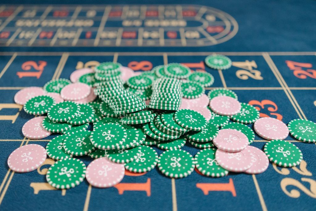 Close-up of a roulette table with a pile of green and pink poker chips.