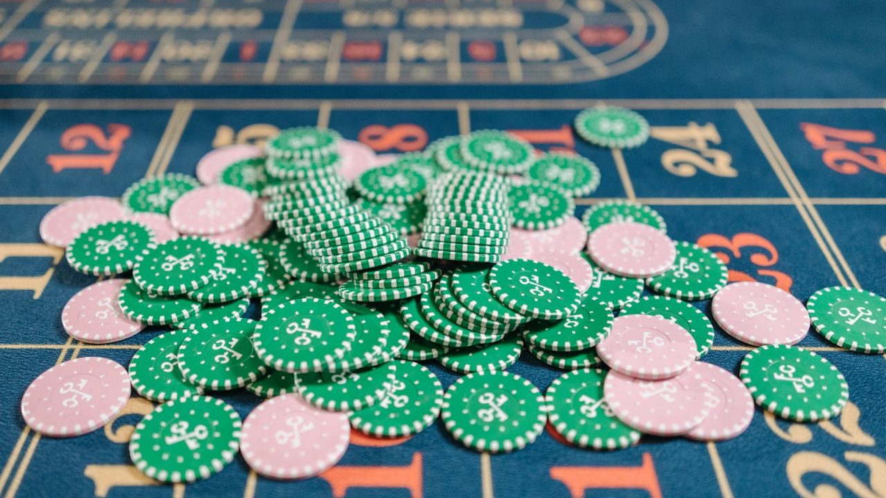 Close-up of a roulette table with a pile of green and pink poker chips.
